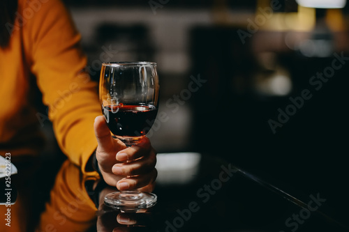 Woman holding a glass of re wine with vintage tone.
