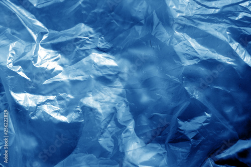 Crumpled transparent plastic surface in navy blue tone.