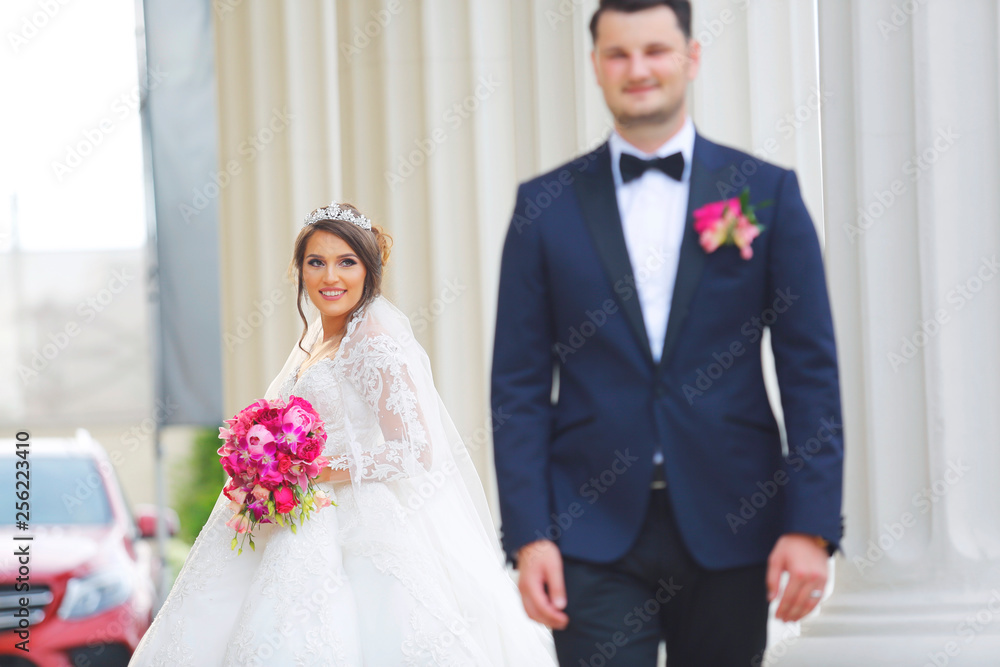 Beautiful wedding couple posing near column