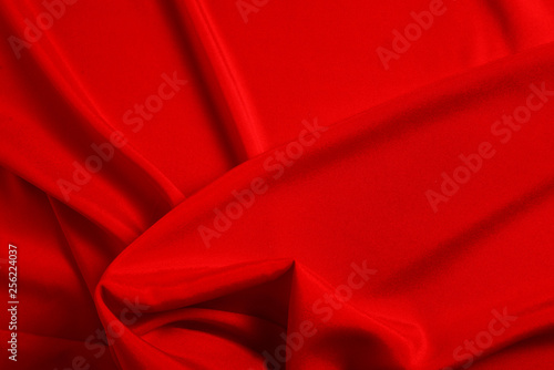 Red silk or satin luxury fabric texture can use as abstract background. Top view.