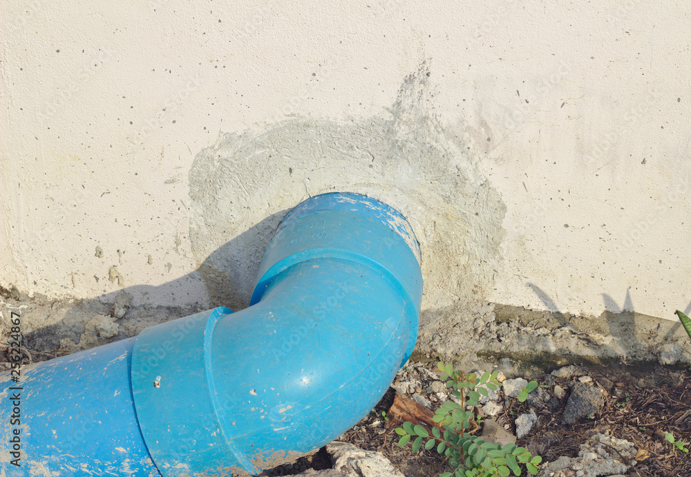Blue pvc drainage pipe outside the concrete wall.Blue PVC drainage pipe