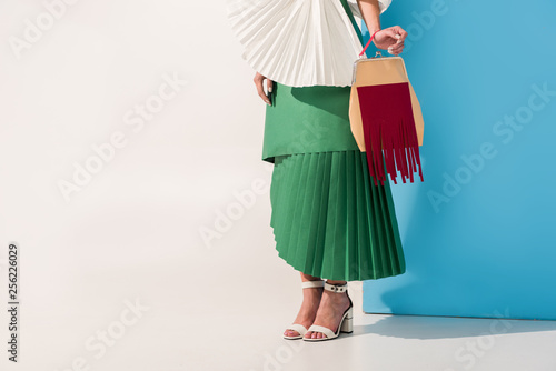 cropped view of stylish girl in paper clothes on blue and white with copy space