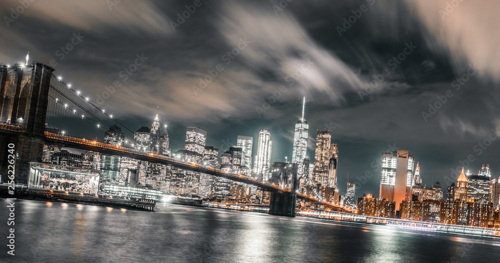 long exposure wispy clouds dominate the brooklyn bridge and downtown Manhattan