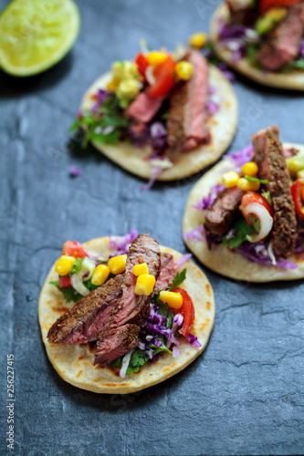 Beef steak tortillas with avocado, sweet corn, tomato salsa and red cabbage