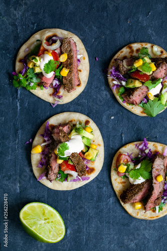 Beef steak tortillas with avocado, sweet corn, tomato salsa and red cabbage