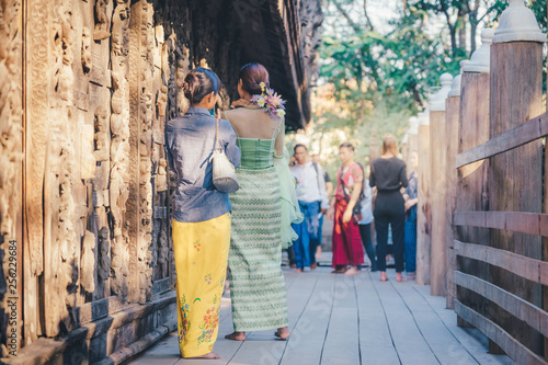 Female tourist take a photo at Shwe Nan Daw Kyaung (Golden Palace Monastery) in Mandalay, Myanmar. © JinnaritT
