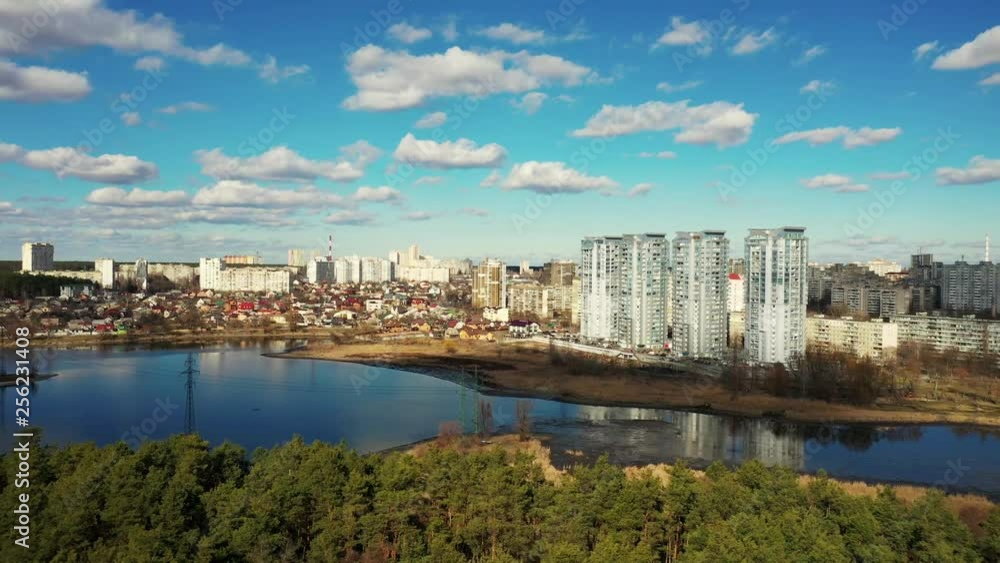 Aerial sidewards shot, flying over a forest, large houses in the background. Aerial sidewards shot, flying over a forest, large houses in the background.