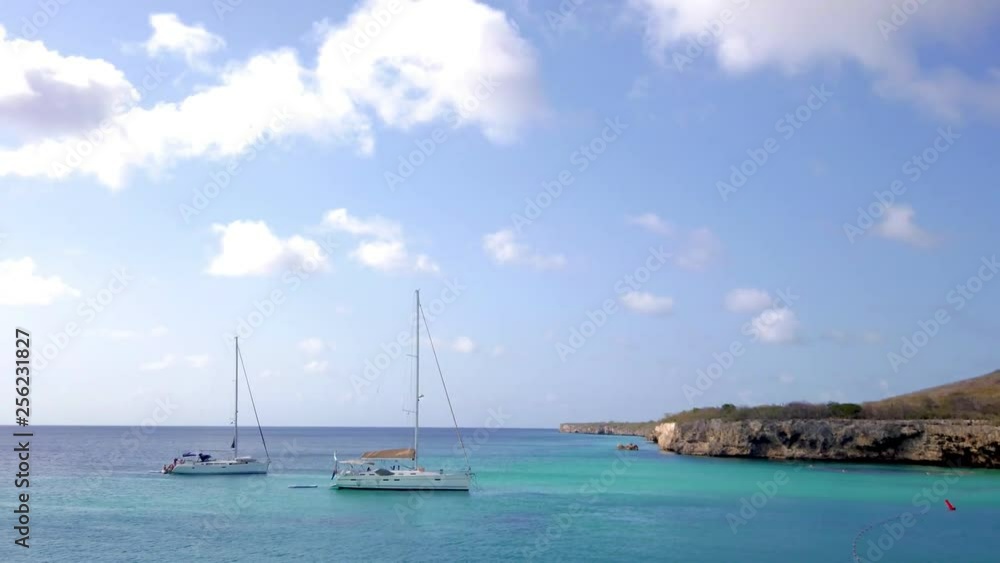 Caribbean luxury sailing, sailboats in bay with white sand and turquoise blue waters, blue skies with white puffy clouds, travel, leisure and nautical concept, copy space available Caribbean luxury sailing, sailboats in bay with white sand and turquoise blue waters, blue skies with white puffy clouds, travel, leisure and nautical concept, copy space available
