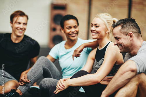 Smiling group of diverse friends sitting together in a gym