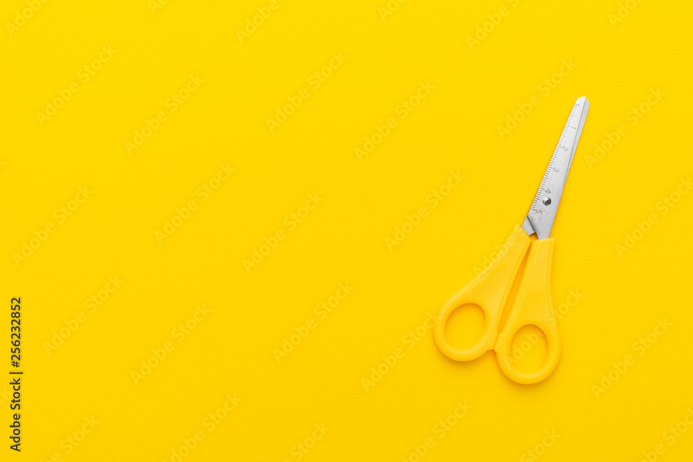 children's scissors on the yellow background with copy space children's scissors on the yellow background with copy space