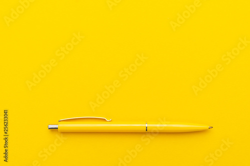 yeloow ballpoint pen on the yellow background photo