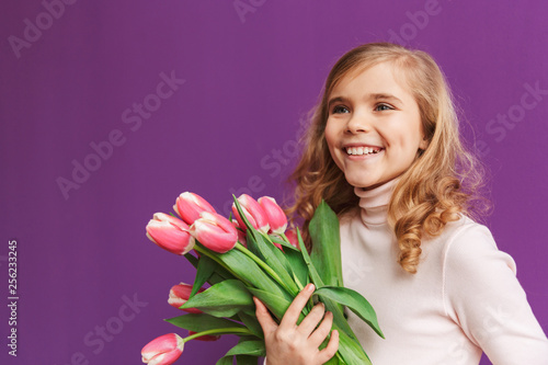 Portrait of a smiling little girl holding bouquet of tulips