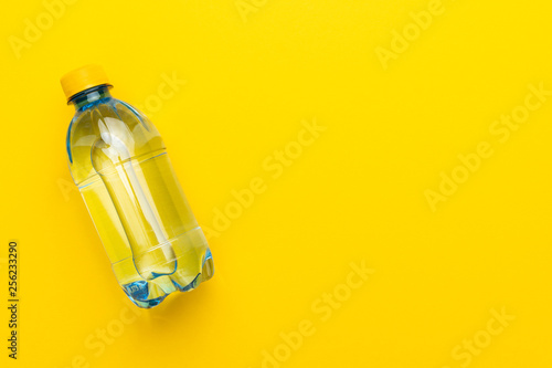 plastic water bottle with yellow cap on the yellow background with copy space