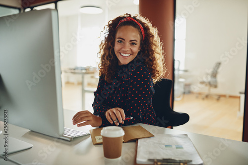 Εκτύπωση καμβά Smiling young businesswoman working online at her workstation