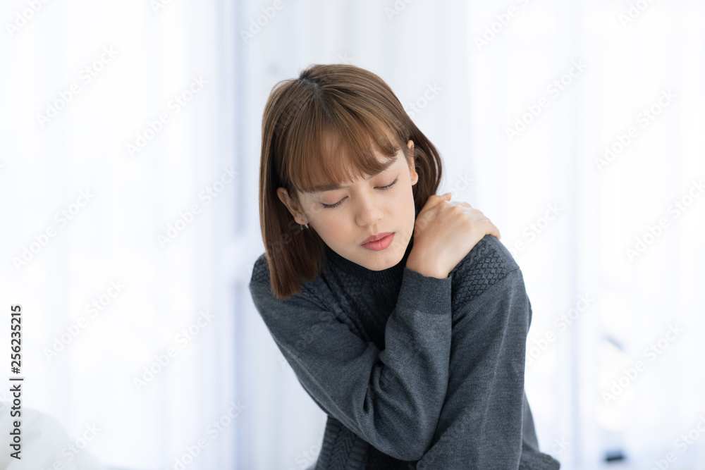 young Asian woman sitting on bed has neck pain after wake up in the morning,Healthcare Concept young Asian woman sitting on bed has neck pain after wake up in the morning,Healthcare Concept