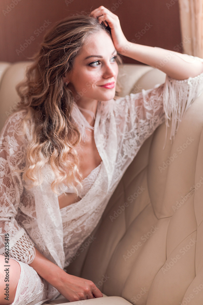 Girl in peignoir sitting on the couch in the room Girl in peignoir sitting on the couch in the room