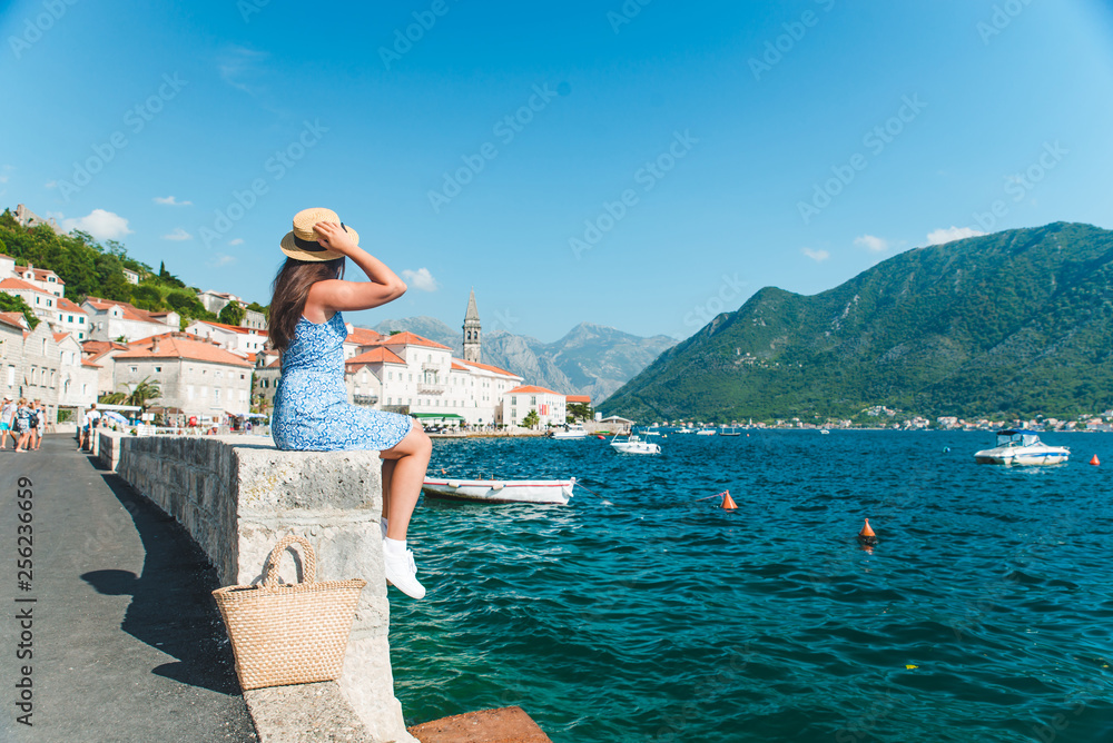 woman walking by Perast city. summer vacation. sea bay