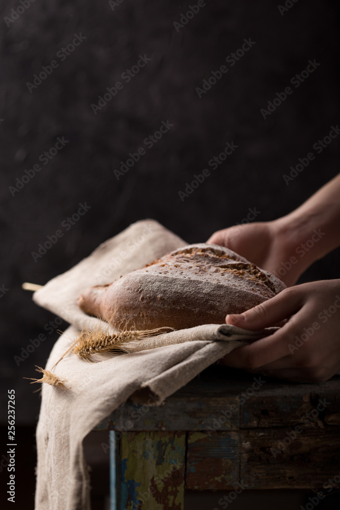 Fresh homemade bread on a gray-blue background, with flax seeds on whole wheat flour. French bread round shape. Bread baking. Unleavened bread