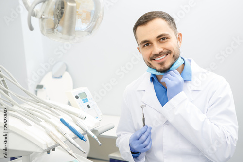 Handsome male professional dentist at his office