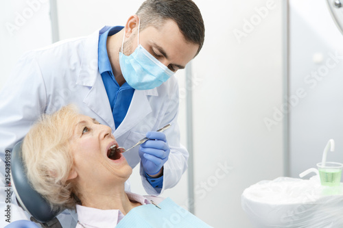 Professional dentist and his senior patient