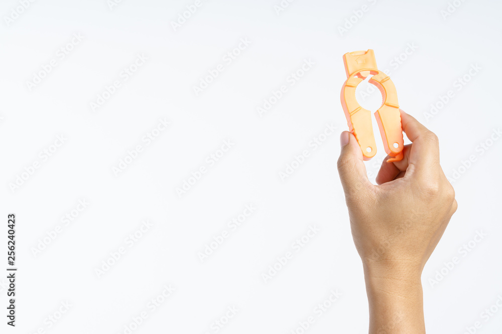 Obraz premium Hand holding plastic bottle cap opener