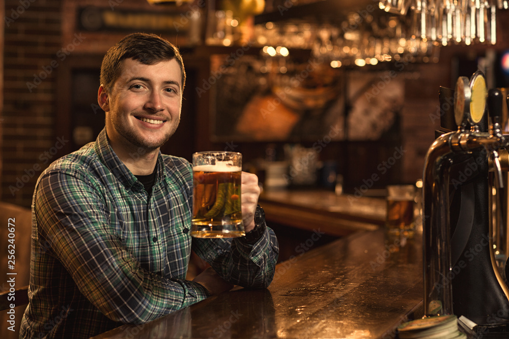 Young man relaxing at the pub having beer