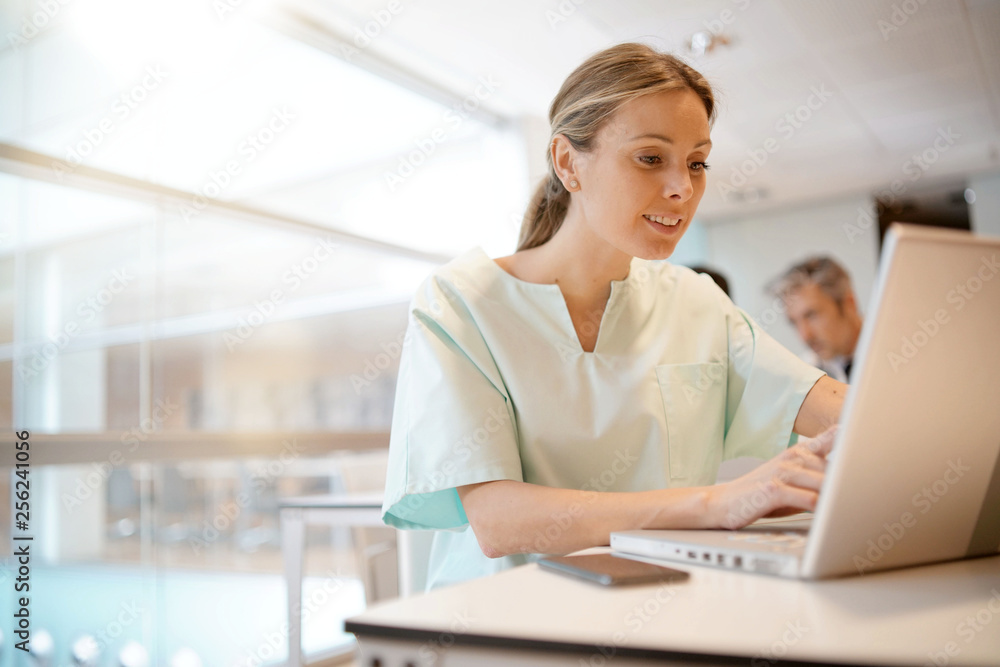 Nurse going through surgical schedule in hospital office Nurse going through surgical schedule in hospital office