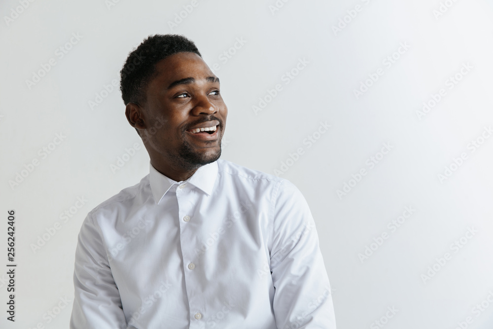 Close up portrait of a happy excited young african american man laughing against gray background. Close up portrait of a happy excited young african american man laughing against gray background.