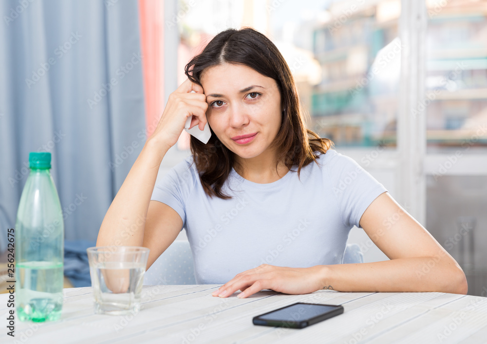 Obraz premium Unhappy young female student sitting with glass of water