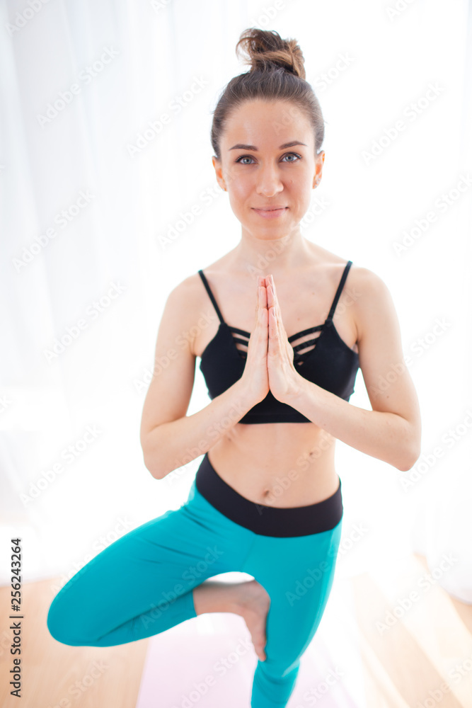 Portrait of gorgeous young woman practicing yoga indoor