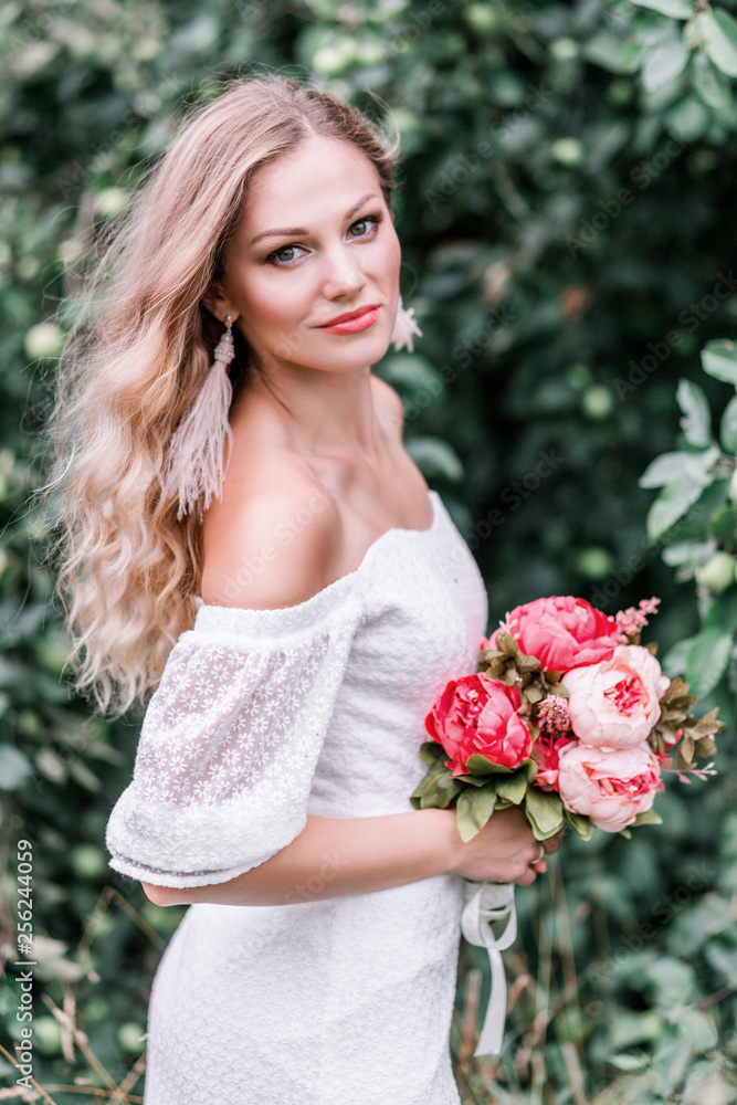 Bride with a bouquet of peonies in her hands Bride with a bouquet of peonies in her hands