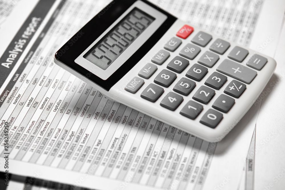 Calculator and reports closeup. Office supplies for working and calculating finance. Business financial accounting concept. Calculator and reports closeup. Office supplies for working and calculating finance. Business financial accounting concept.