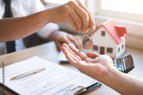 estate agent giving keys of new house to house buyers and explain about insurancehome concept