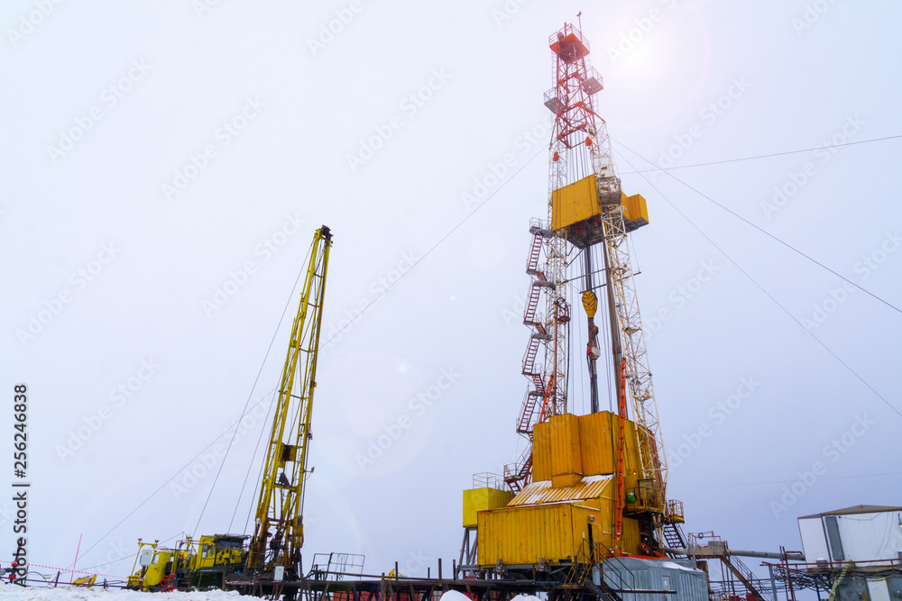 Silhouette image of oil and gas drilling rig in the middle of nowhere with dramatic sky. Onshore land rig in oil and gas industry. Land oil drilling rig blue sky