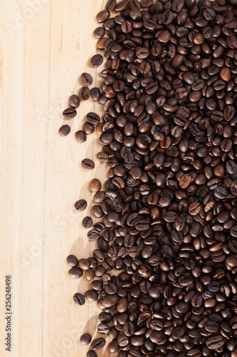 Image of fresh coffee beans on natural wooden background