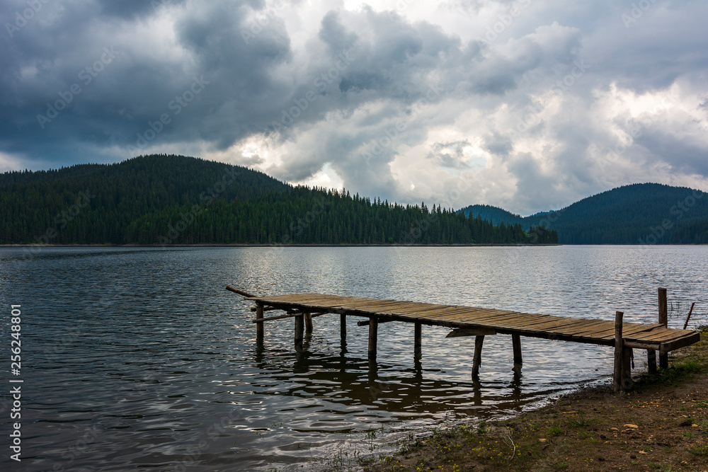 Impressively beautiful Fairy-tale mountain lake with crystal clear water and wooden pier. Breathtaking Scene. Impressively beautiful Fairy-tale mountain lake with crystal clear water and wooden pier. Breathtaking Scene.