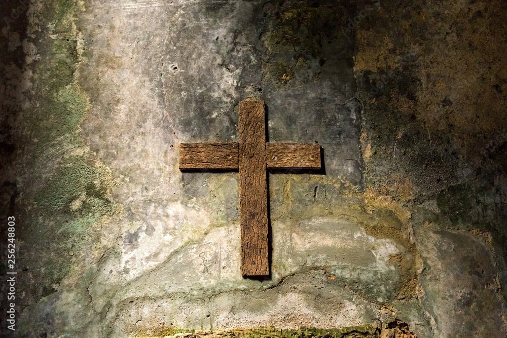 Wood cross hanging on an old grunge wall. An old chross in Convento dos Capuchos Sintra, Portugal