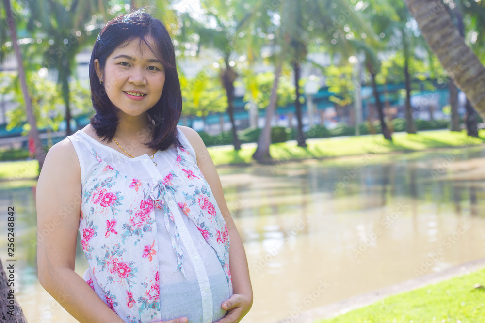 Asian pregnant women posing in city public green park Asian pregnant women posing in city public green park