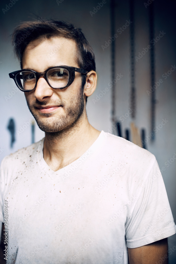 Portrait of carpenter wearing eyeglasses standing in workshop Portrait of carpenter wearing eyeglasses standing in workshop