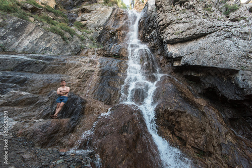 Man at waterfall in Altai Mountains territory