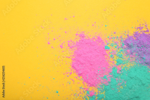 Colorful holi powders on yellow background