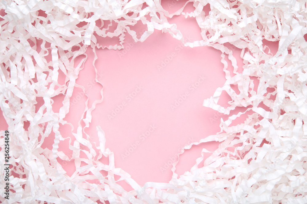 White shredded paper on pink background