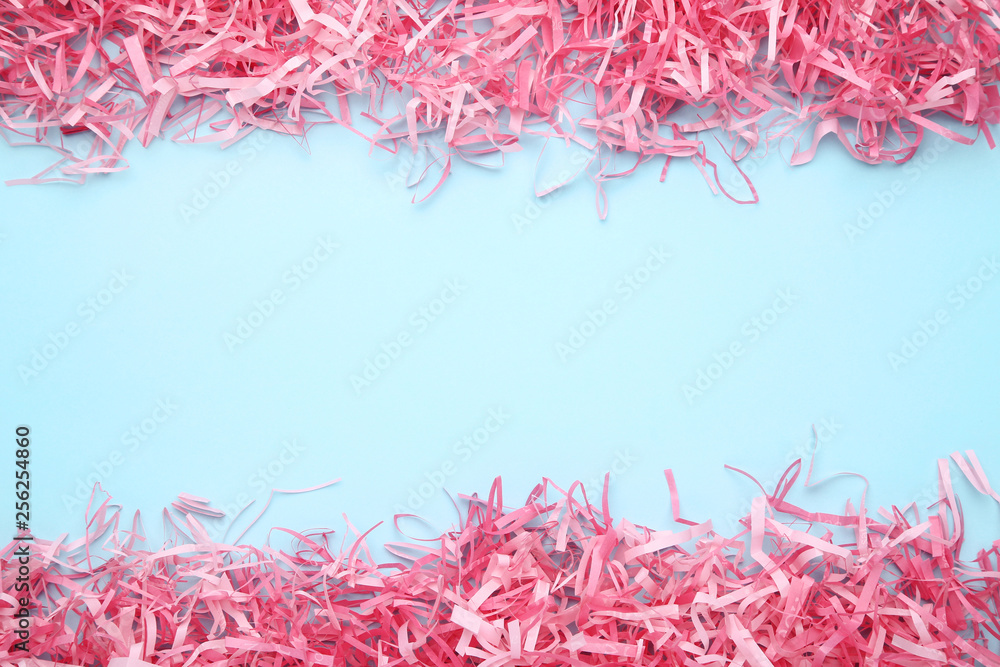 Pink shredded paper on blue background