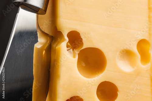 A delicious piece of cheese with cheese knife. photo