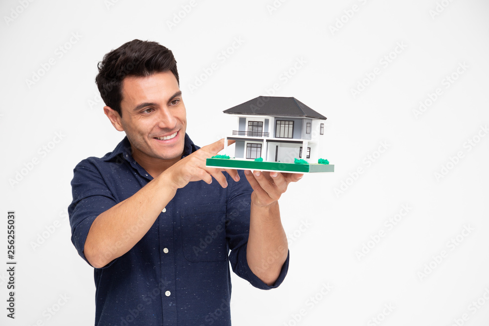 Handsome young Caucasian man inspector holding single home, Home inspection service before transferring to house owner concept Handsome young Caucasian man inspector holding single home, Home inspection service before transferring to house owner concept