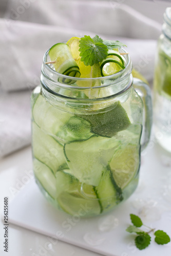 glass of water with lime cucumber and mint close-up