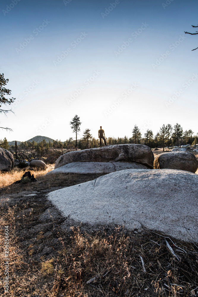 Full length of hiker standing on rock against clear sky Full length of hiker standing on rock against clear sky