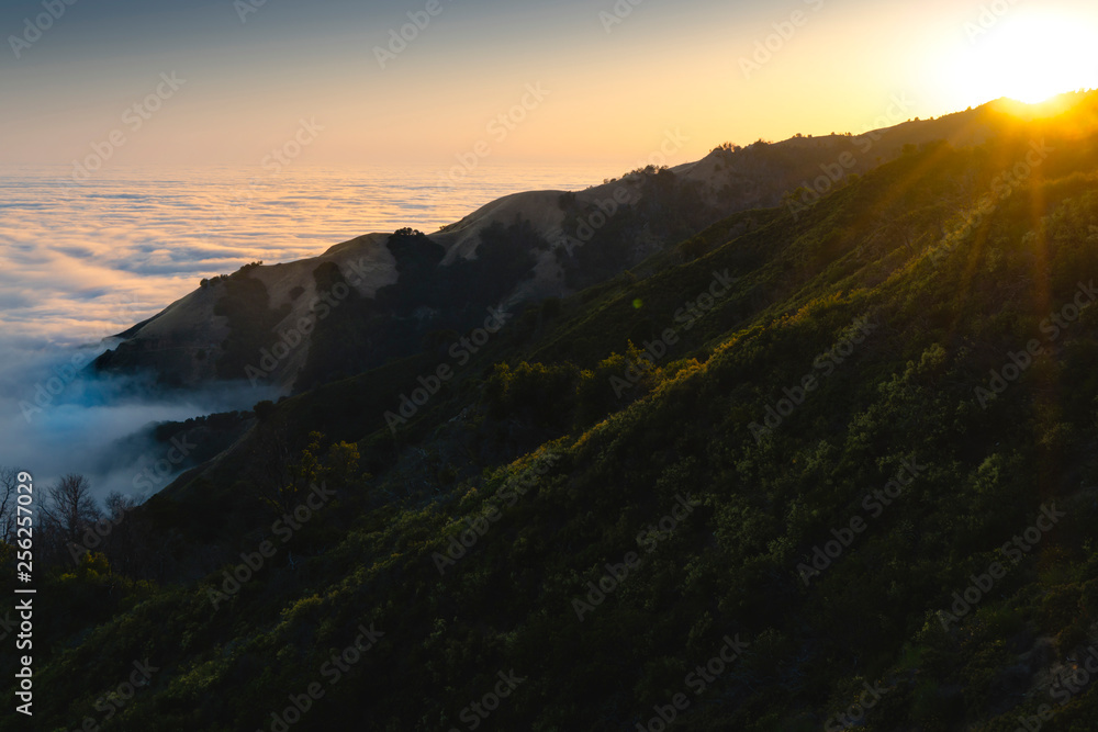 Scenic view of mountain by cloudscape during sunset Scenic view of mountain by cloudscape during sunset