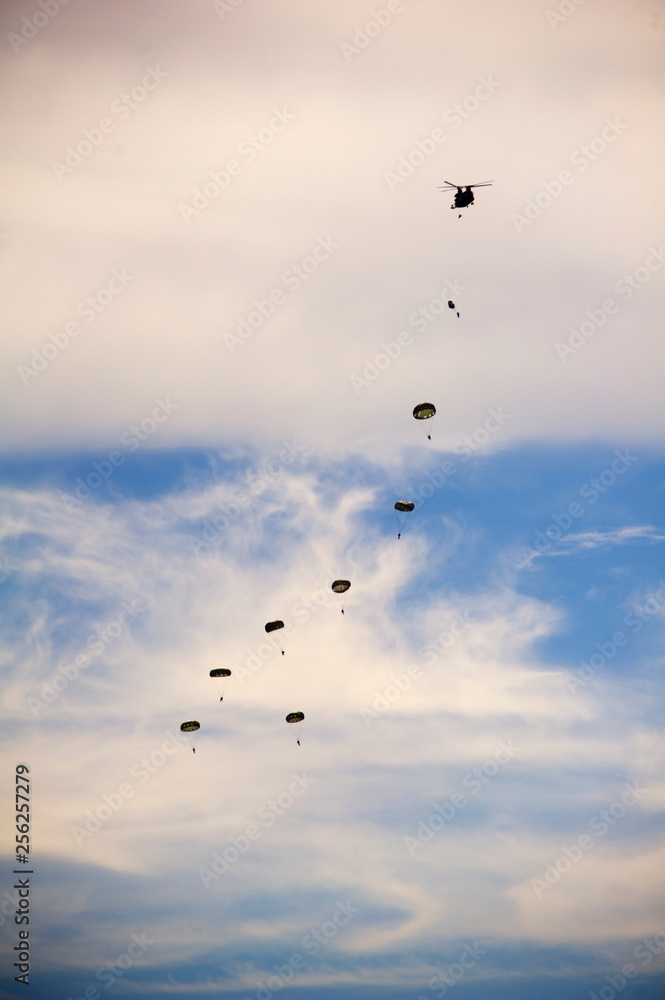 Low angle view of paratroopers flying in cloudy sky during airshow Low angle view of paratroopers flying in cloudy sky during airshow