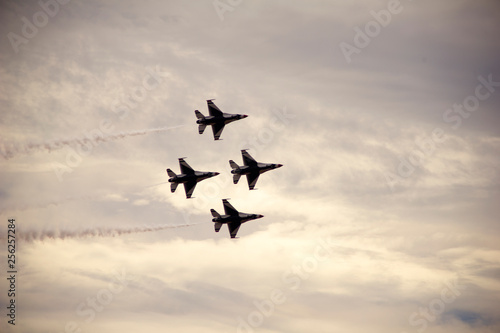 Low angle view of fighter planes flying in cloudy sky during airshow photo
